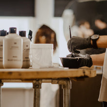 Person preparing a haircut with hair products on a table.